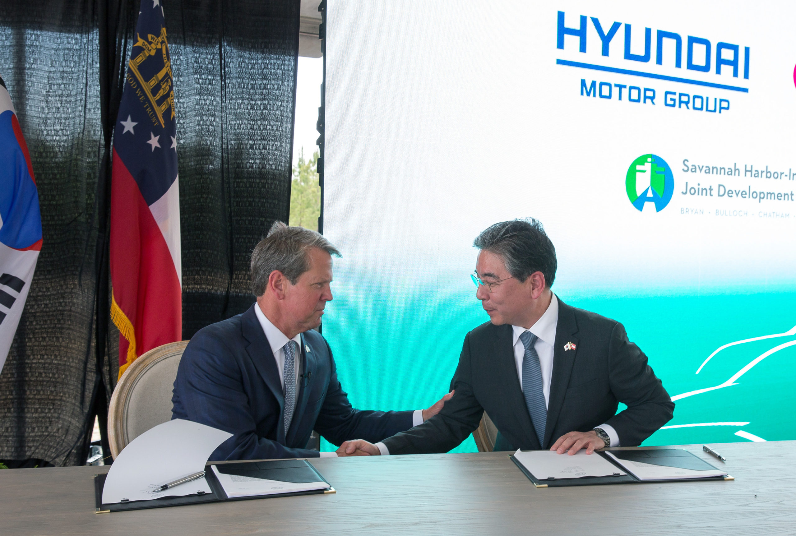 Georgia Governor Brian P. Kemp, left, and Hyundai Motor Company President and CEO Jaehoon Chang sign an agreement for Hyundai's new EV facility in the state.