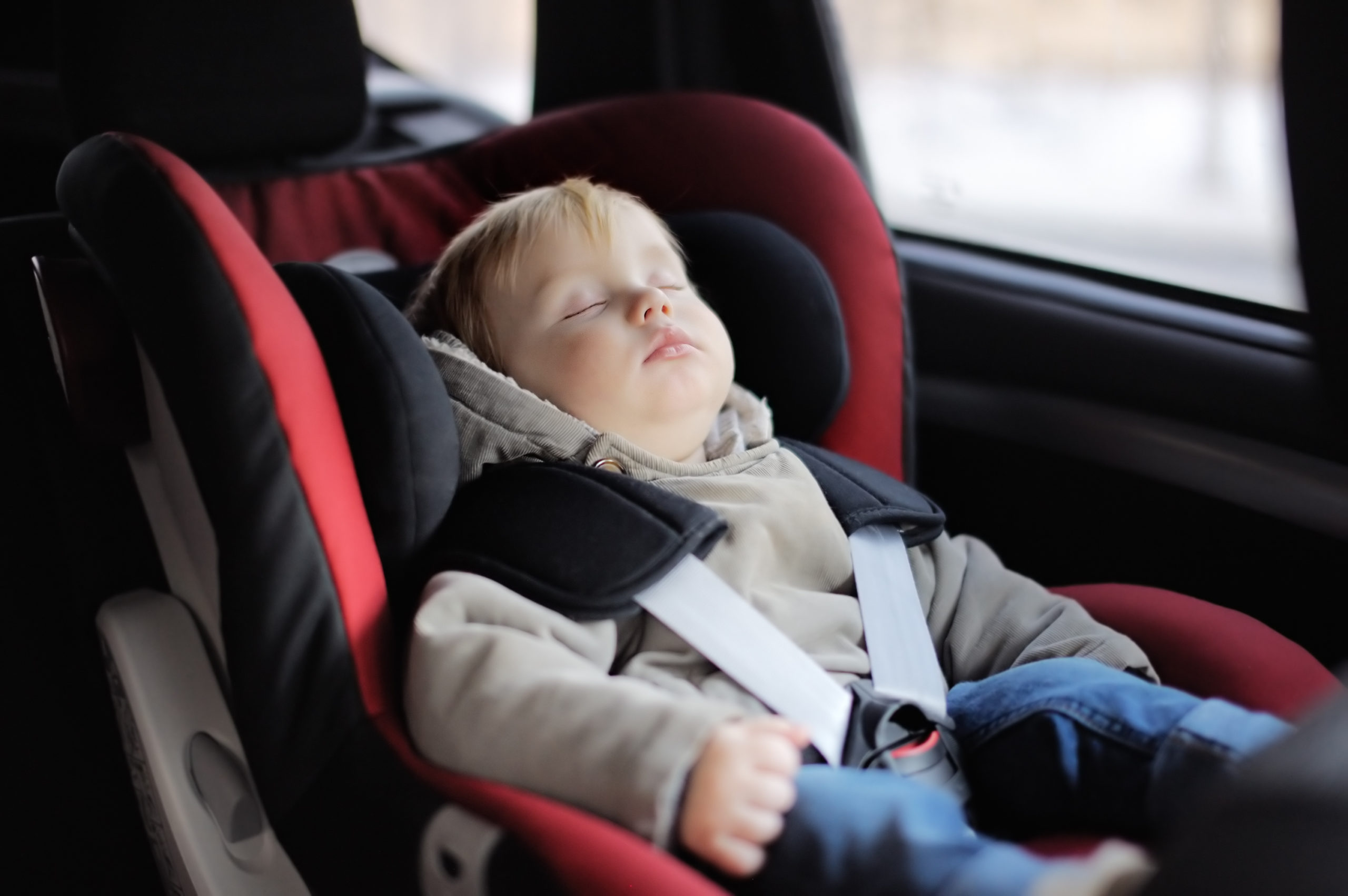 Toddler sleeping in a car