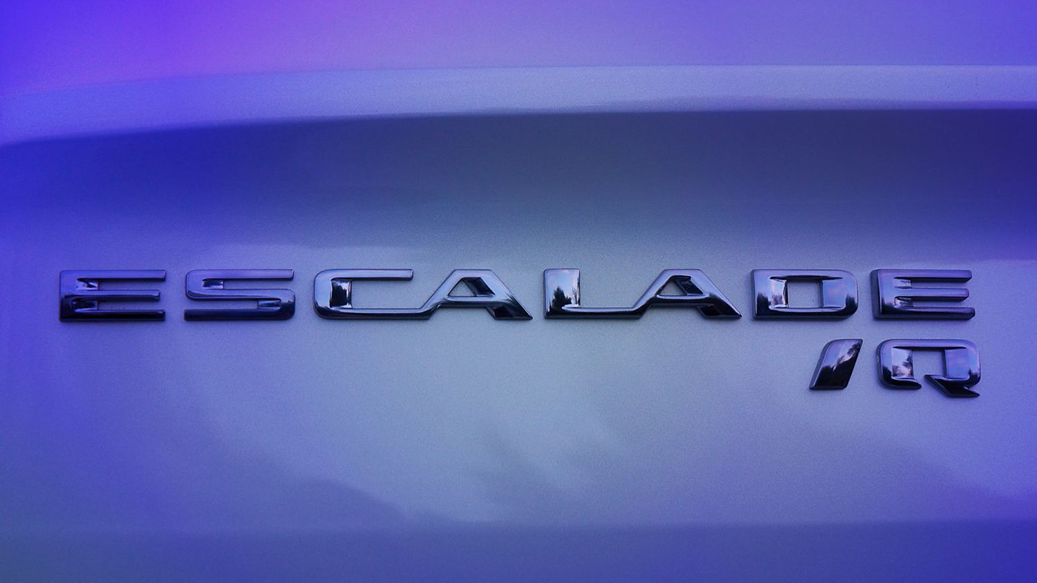 A close-up of the Cadillac ESCALADE IQ name badge seen on the vehicle. Preproduction model shown.