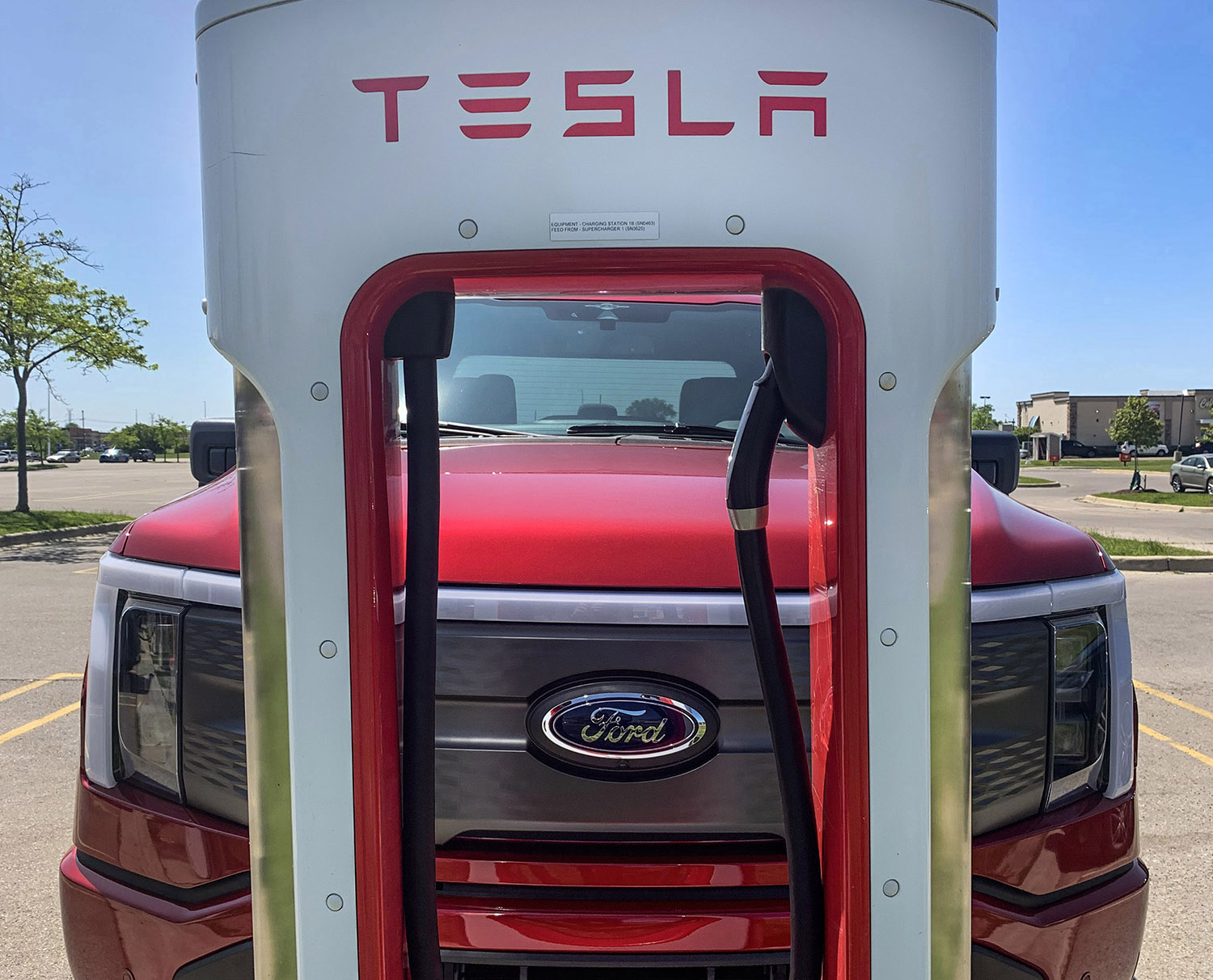 A Ford F-150 Lightning at a Tesla Supercharger station