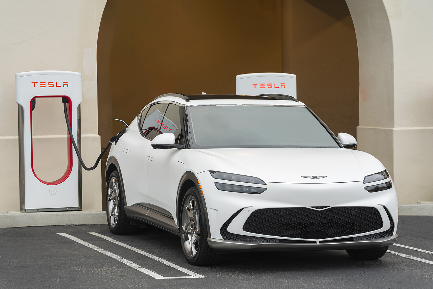 A Genesis GV60 charging at Tesla's Supercharger